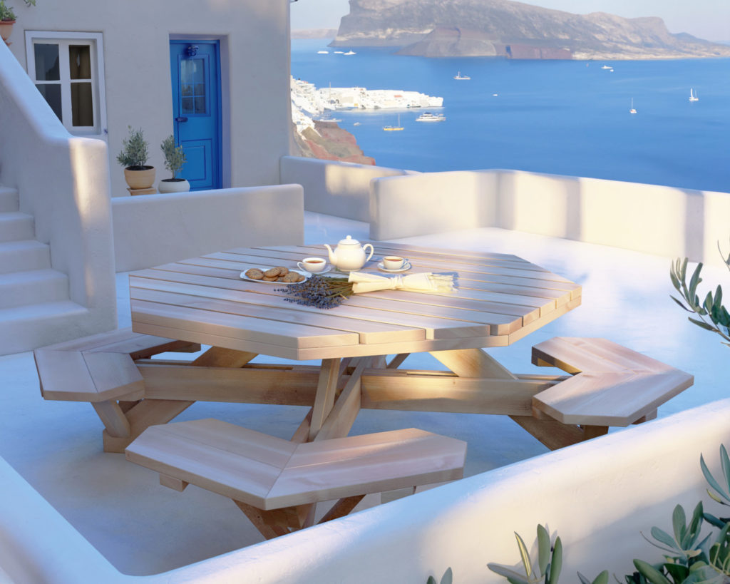 Octagonal wooden picnic table overlooking beautiful Santorini seascape
