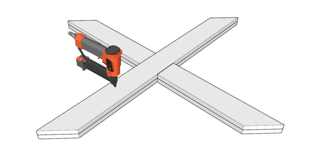 Adding glue to the crossbuck and attaching boards together using a nail gun