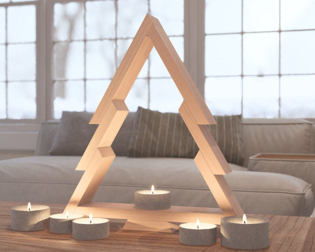 Modern wooden Christmas tree design with surrounding candles on a table by a snowy window.