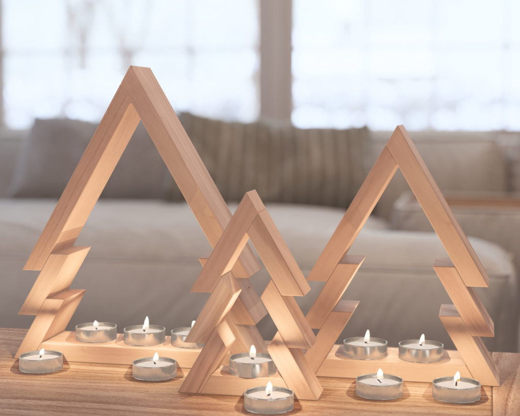 Modern wooden nested Christmas trees with tealight candles on a wooden surface.