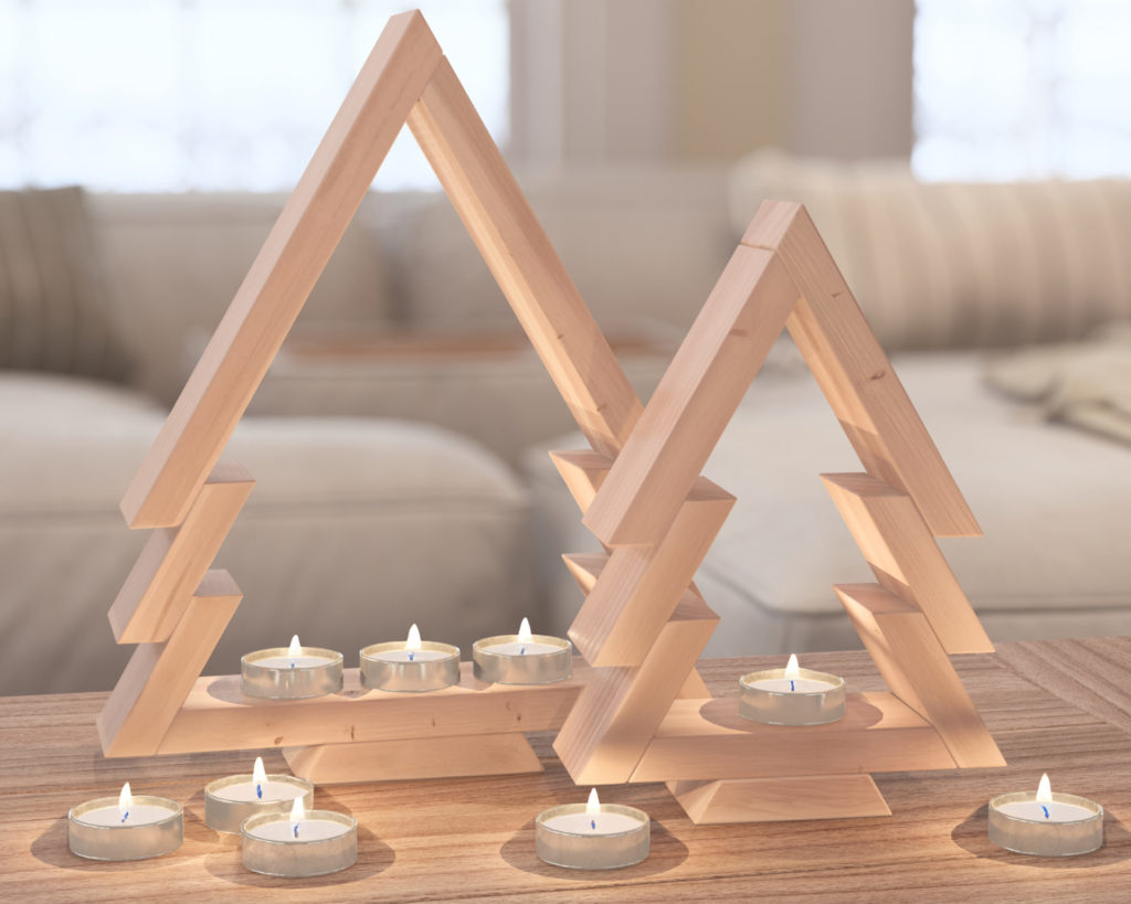 Nested wooden Christmas tree decorations with candle holders, made from 1x3 lumber and assembled with pin nails and glue, on a wooden floor and a mantelpiece.