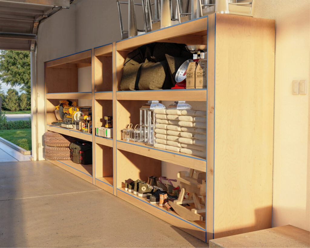 Versatile DIY garage shelf made from 2x4 lumber and plywood, featuring separate storage areas for different sized items, with full casing around each section.