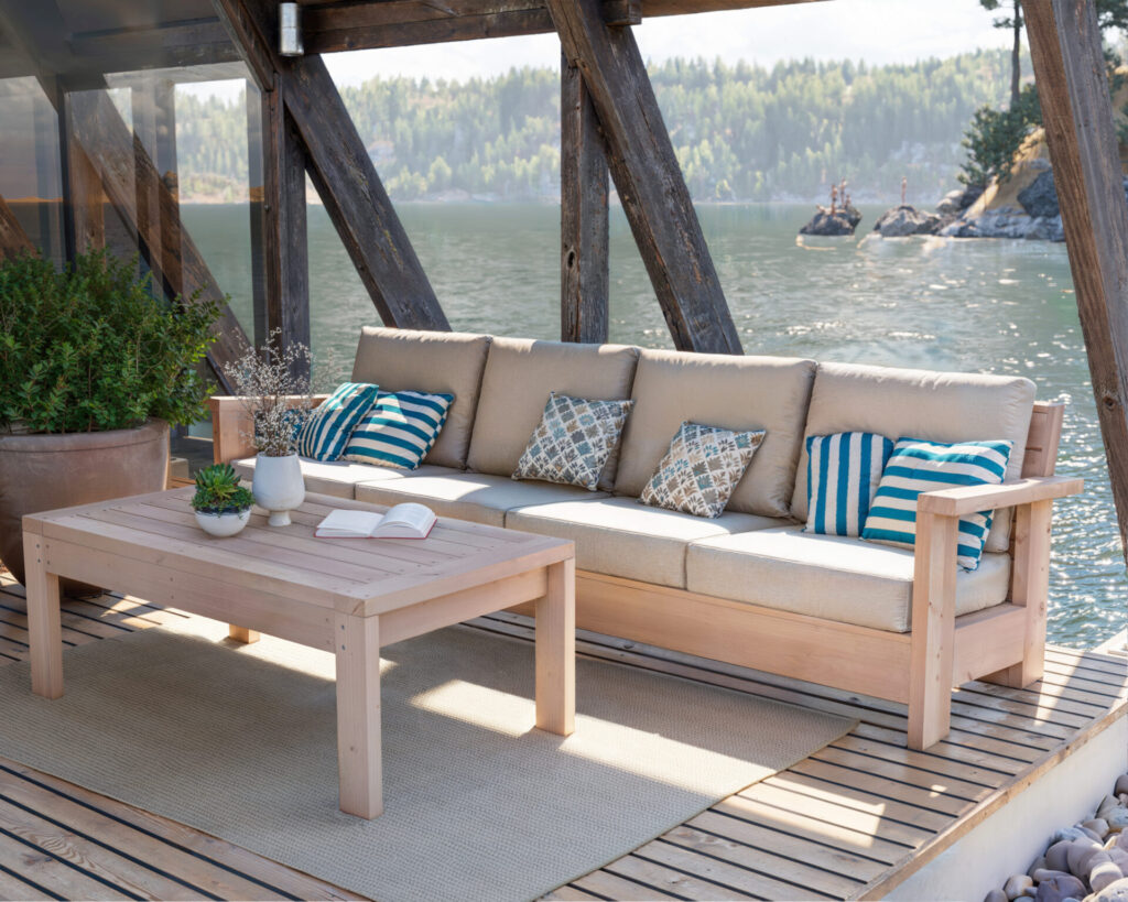 Stylish DIY wooden bench with comfortable cushions set against a serene lakeside backdrop, perfect for a relaxing retreat.