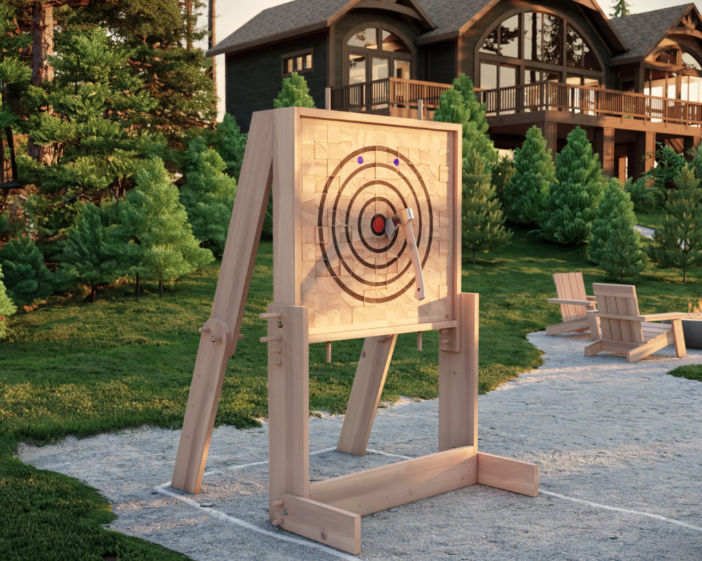 DIY wooden axe throwing target in outdoor setting with lush greenery and cabin in the background.
