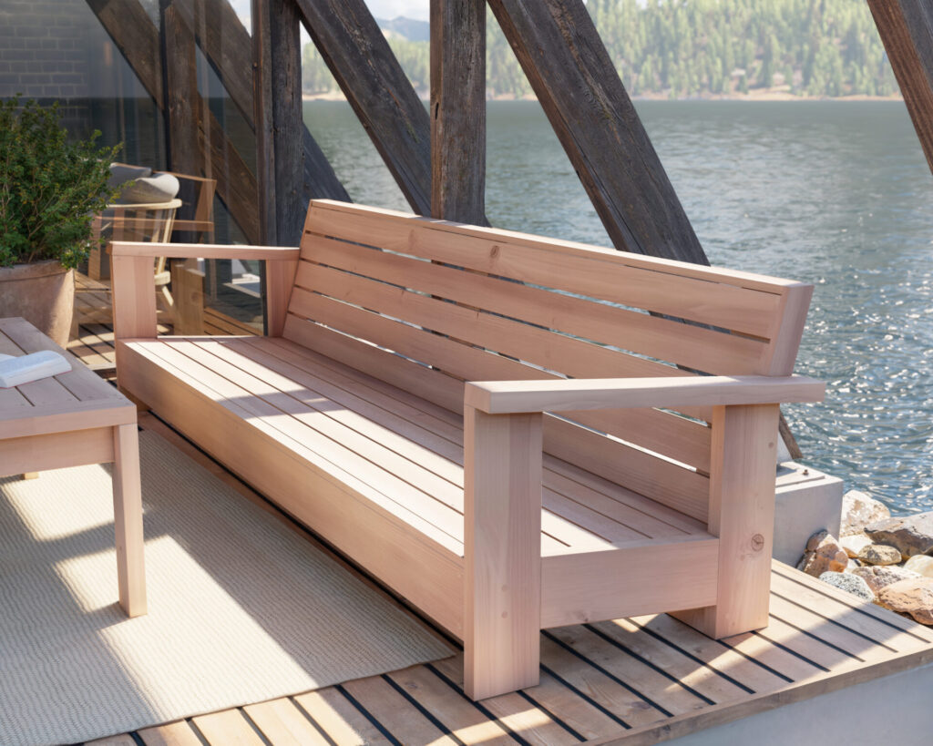 Stylish DIY wooden bench with comfortable cushions set against a serene lakeside backdrop, perfect for a relaxing retreat.