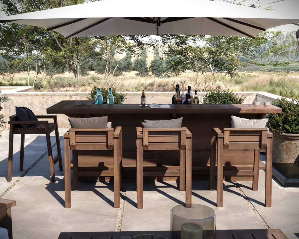 DIY L-shaped outdoor home bar made from common dimensional lumber, featuring a serving counter, adjustable shelf, and seating for four.