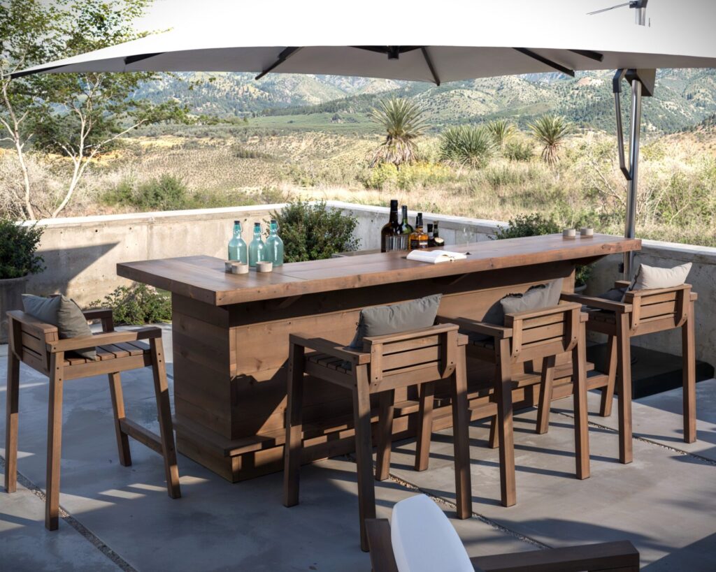 DIY L-shaped outdoor home bar made from common dimensional lumber, featuring a serving counter, adjustable shelf, and seating for four.