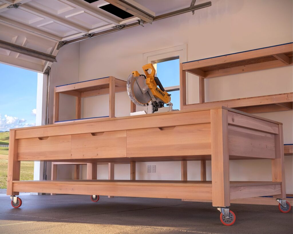 Custom-built DIY garage workbench with drawers and lumber storage in a well-organized garage.