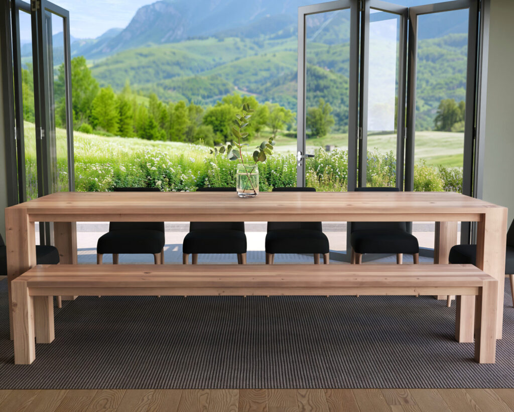 Front view of a large wooden dining table and bench set with a scenic outdoor backdrop.