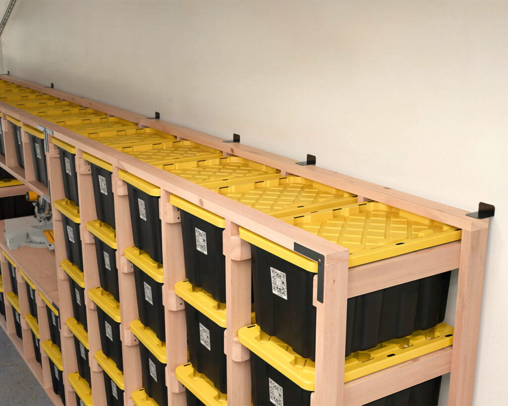 DIY 27-Gallon Tote Storage Rack in a garage, holding multiple black and yellow HDX storage totes, with a workbench integrated into the rack and a person scanning a tote using a QR code.