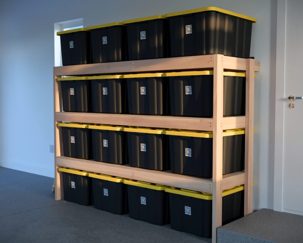 DIY garage shelving unit built with 2x4 lumber and plywood, designed to hold 27-gallon storage totes efficiently. The shelving features customizable configurations, making it a beginner-friendly and cost-effective storage solution for garages.