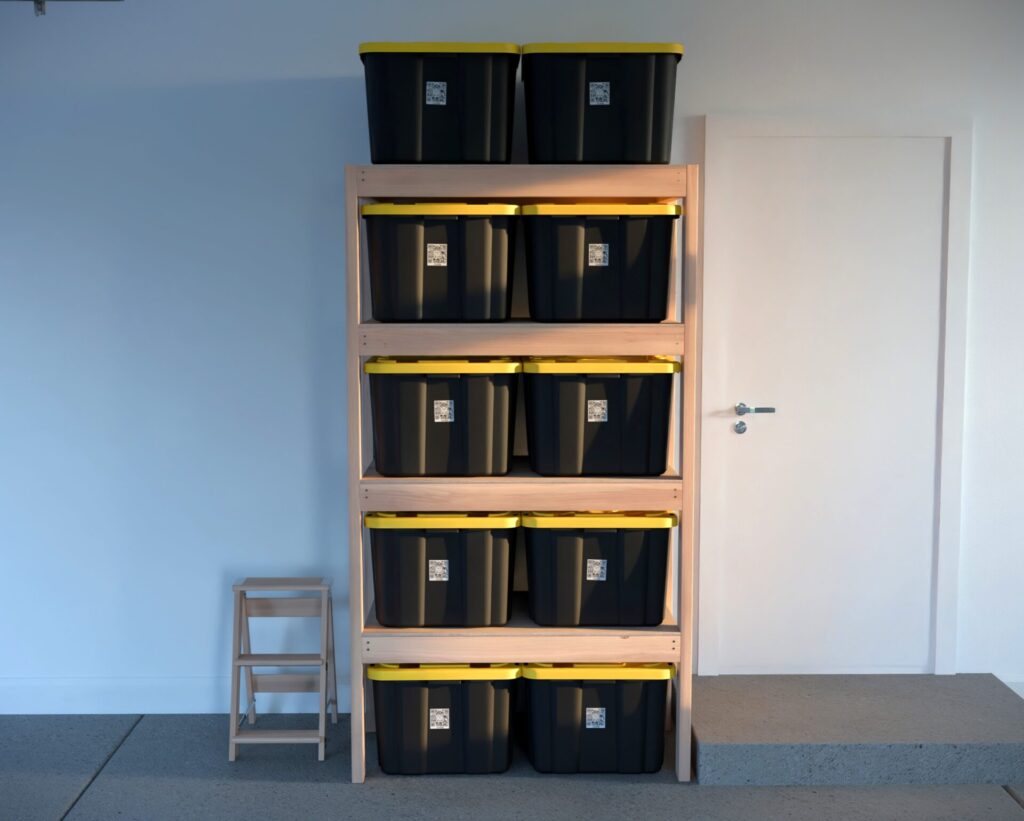 DIY garage shelving unit built with 2x4 lumber and plywood, designed to hold 27-gallon storage totes efficiently. The shelving features customizable configurations, making it a beginner-friendly and cost-effective storage solution for garages.